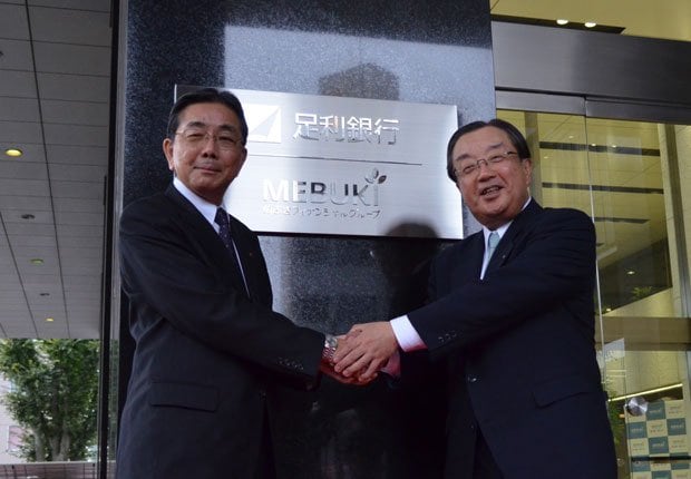 「めぶきＦＧ」の新しい看板を前に握手する、同グループの寺門一義社長（左）と松下正直副社長　（ｃ）朝日新聞社
