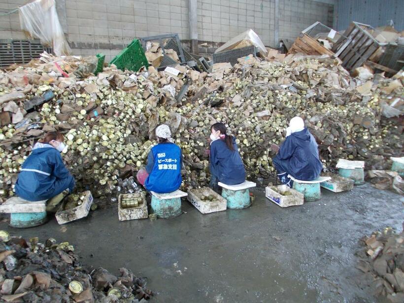 2011年7月、泥まみれになった缶詰を回収するボランティアら／木の屋石巻水産提供