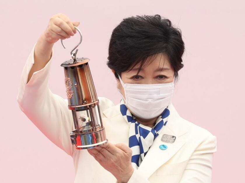 東京五輪の式典で聖火がともるランタンを掲げる小池百合子東京都知事（C)朝日新聞社