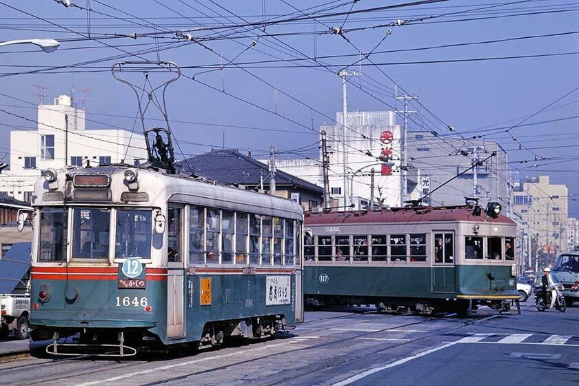 鮮明なコダクロームIIフィルムで撮影した12系統の市電とポール集電の京福電鉄／嵐山本線の電車。　西大路三条（撮影／諸河久：1975年11月22日）