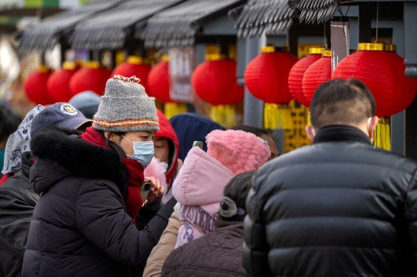 春節の連休中、公園でマスクをつけて過ごす女性＝1月26日、北京（photo　アフロ）