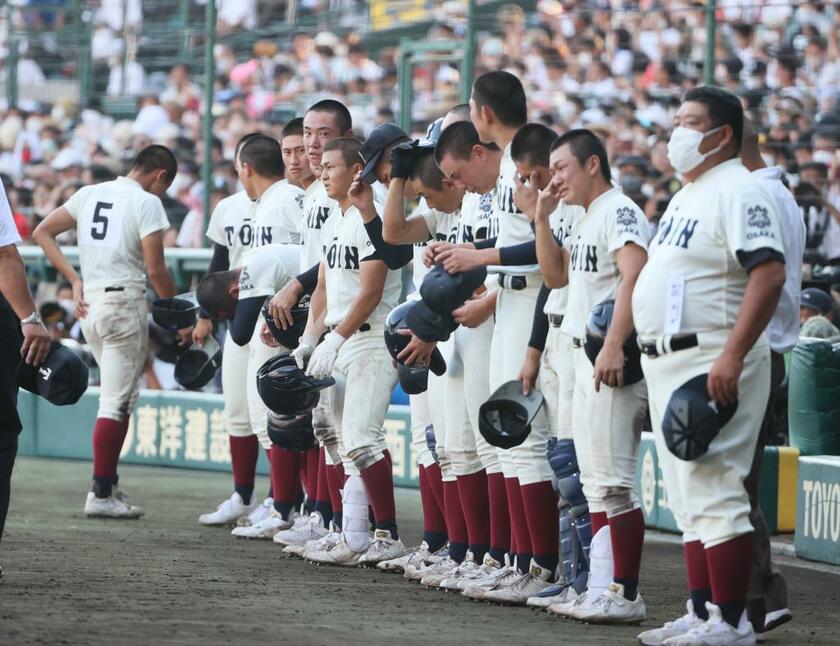 涙をぬぐいながらベンチ前に整列する大阪桐蔭の選手たち