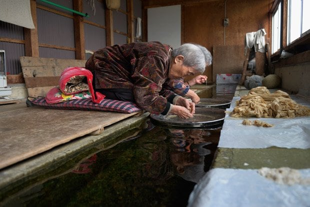 「ちり取り」。川屋と呼ばれる、井戸水が流れる作業場で、こうぞの内皮に付着している塵（ちり）やごみを手でひとつずつ取り除いていく（撮影／門間新弥）