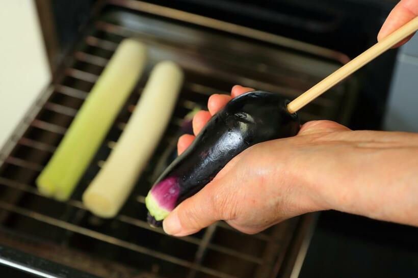 【ワンポイントアドバイス】グリルの熱が通りやすいよう、なすはお尻から菜箸で穴を開ける。　（撮影／写真部・松永卓也）