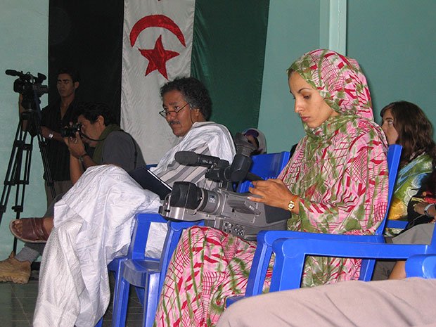 民族衣装メルファをまとった女性カメラマン・ハディジャ。難民キャンプの集会場で大統領の演説を撮影し、西サハラ人向けのテレビで放映する（撮影／川名生十）