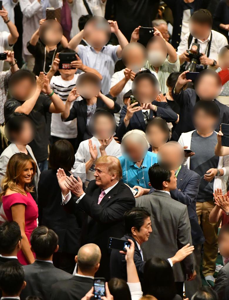相撲を観戦したトランプ米大統領を撮影しようとスマホをかまえる観客。SNSに投稿するのだろうか（写真は一部加工しています）　（ｃ）朝日新聞社