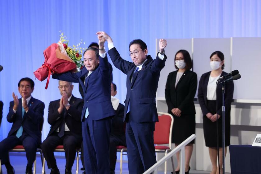岸田文雄前政調会長（当時、右）は９月２９日、自民党総裁選で新総裁に選ばれ、菅義偉首相（当時、左）とともに両手を上げる（ｃ）朝日新聞社