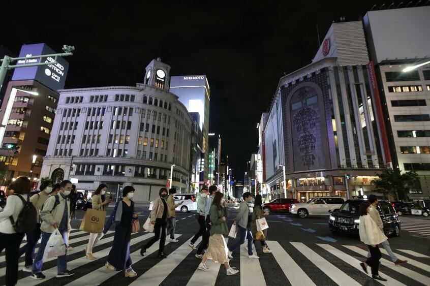 3度目の緊急事態宣言が発出された4月25日夜、東京都の要請を受け、銀座では午後8時以降一部商業施設の照明が消えた。(c)朝日新聞社