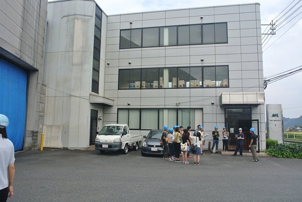 発電設備を有する銘建工業と、説明を受けるツアー参加者