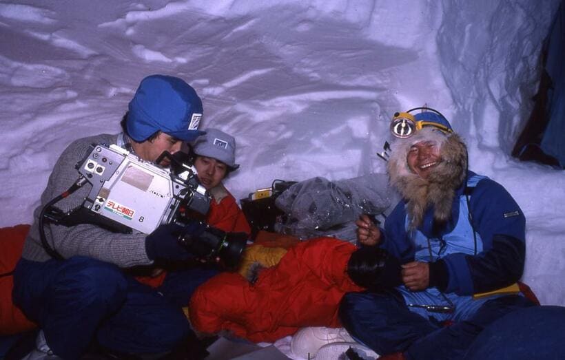１９８４年１月下旬、マッキンリーのベースキャンプで取材に答える植村直己さん（右）。ベースキャンプでは、雪洞づくりの練習や装備の最終確認を行った。左の２人は大谷さんに同行したテレビクルー（写真：大谷映芳さん提供）