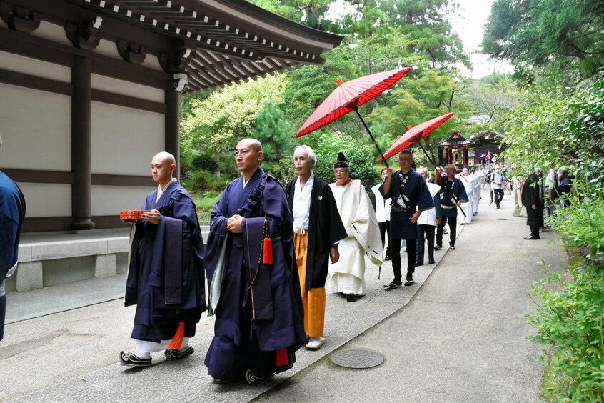 祭礼の会場に向けて円覚寺の境内を歩く僧侶や神職=2023年9月