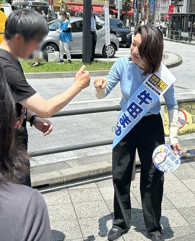 有権者とグータッチをする牛田氏（撮影/大谷百合絵）
