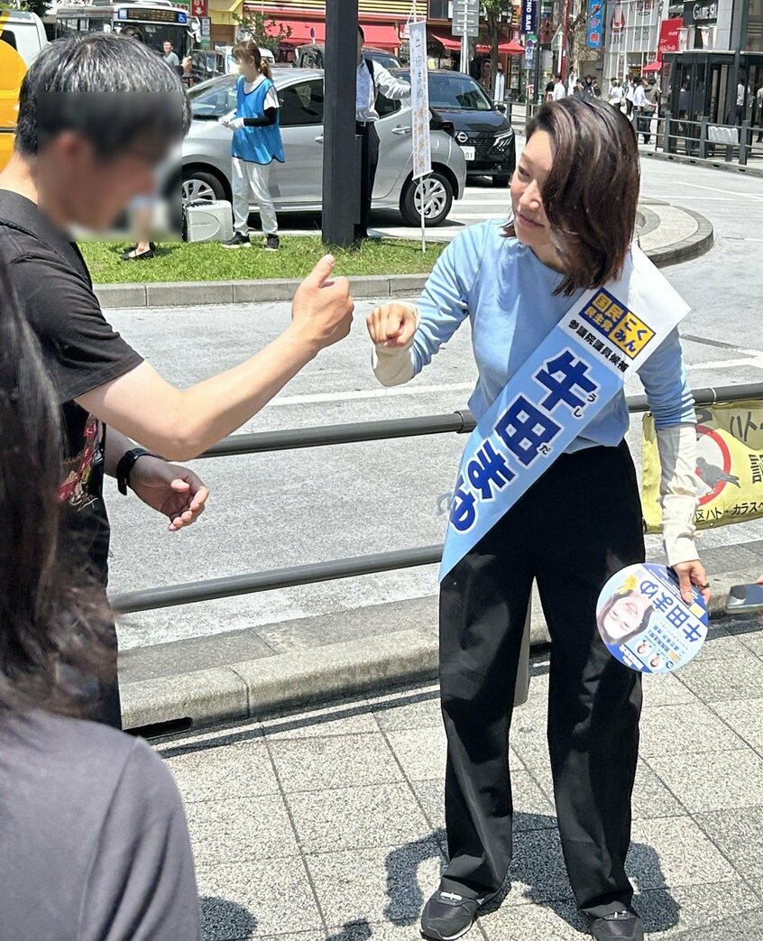有権者とグータッチをする牛田氏(撮影/大谷百合絵)