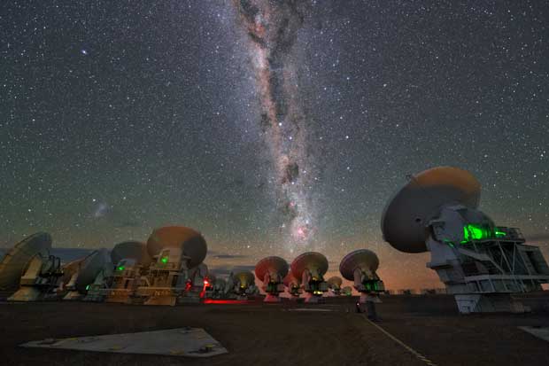 南米チリのアタカマ高地・標高５千メートル地点の山頂施設にある、アルマ望遠鏡のアンテナ群。夜空には天の川が見える（提供・ＥＳＯ／Ｙ．　Ｂｅｌｅｔｓｋｙ）