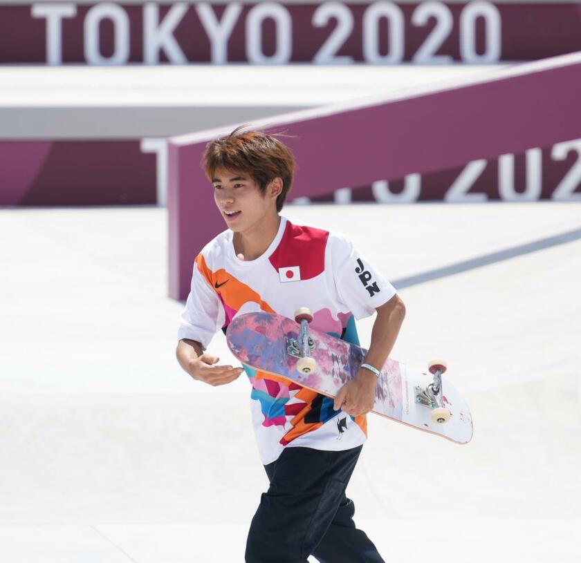 男子ストリート決勝でトリックを成功させ、スケートボードを抱えてコーチの元に走る堀米雄斗（ｃ）朝日新聞社
