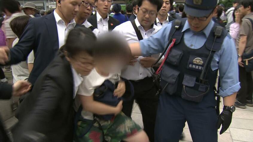 安倍首相の演説時にヤジを飛ばし、北海道警に排除される女性(北海道テレビ放送提供)