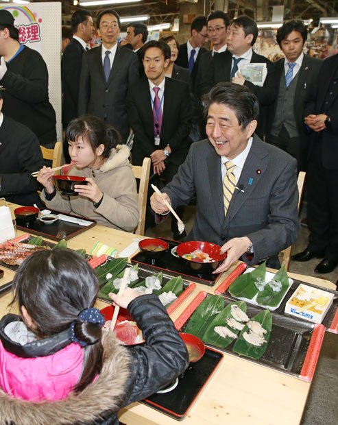 被災地で子どもたちと海鮮丼を食べる安倍首相。これもイメージ戦略か／２月２１日、宮城県塩釜市　（ｃ）朝日新聞社