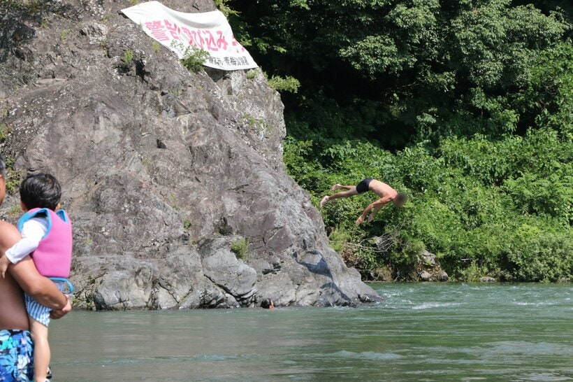 岩の上から川に飛び込む人。東京都青梅市の多摩川で＝米倉昭仁撮影