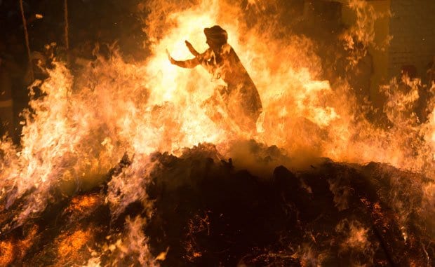 火渡り春の訪れを祝い、悪魔を払う「ホーリー祭」の前夜、たき火を囲んで祈るのが習わしだ。ある片田舎では、一人の男が、3メートルほどの火柱を上げて赤々と燃えさかる炎の中を裸足で渡り切り、何千人もの観客から大歓声を受けていた（撮影／藤本将史）
<br />