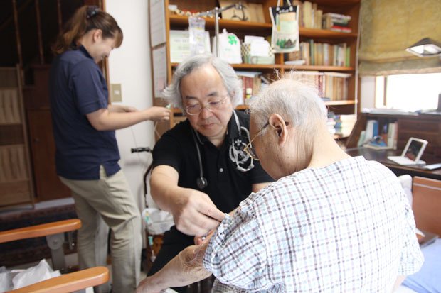 梅田医師（中央）は定期的な訪問診療に加えて、何かあればいつでも駆けつけているが、病棟の存在が患者の安心感につながっている（提供／松原アーバンクリニック）