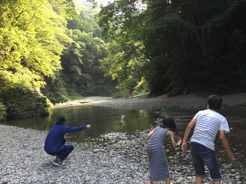 奥多摩にて。見えづらいが、石で水切りをする山崎さん。「運動神経ゼロでしたが、石切りは案外うまくて驚きました。ちなみに、彼は縄跳（なわとび）ができませんでした」（2017年7月20日）（写真提供・山崎 薫）