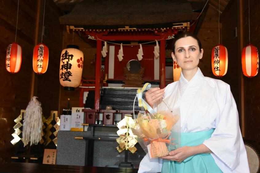 梅林テチャナさん。手に持っているのは、激励に訪れた参拝客が手渡したフラワーアレンジメント (撮影/高鍬真之)