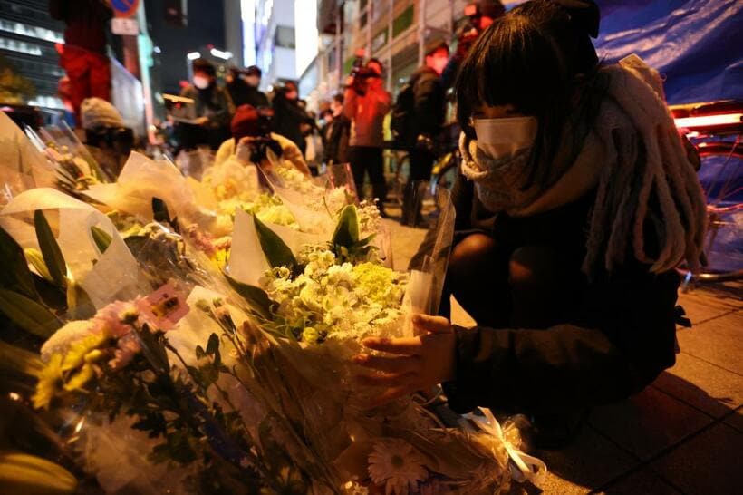 火災があった曽根崎新地のビル前で花を手向ける女性