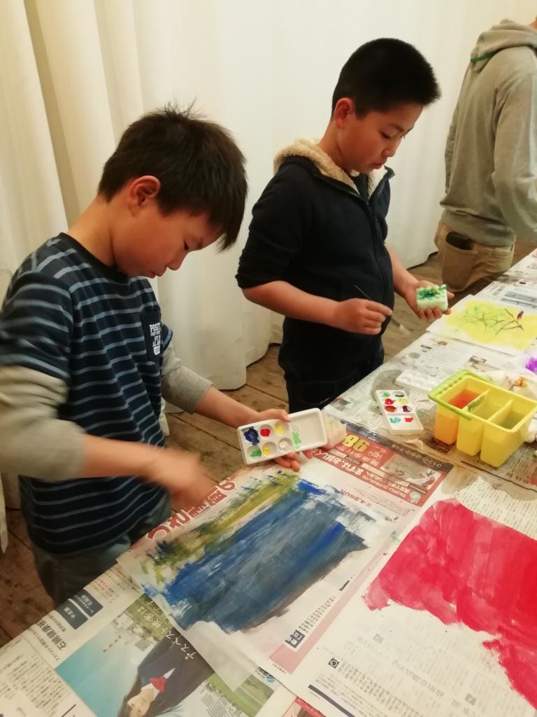 アクリル絵の具で様々なパターンの色紙を作る子どもたち