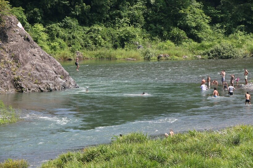 岩の上から川に飛び込む人。東京都青梅市の多摩川で＝米倉昭仁撮影