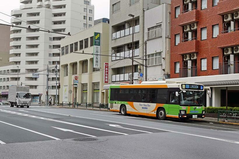 大塚三丁目停留所に止まる上58系統上野松坂屋行き都バス。往年の街並みは失われ、無機質な街に変貌していた。（撮影／諸河久：2019年11月24日）