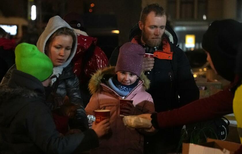 リビウ駅の前の広場でボランティアからスープを受け取る、東部から避難してきた人たち