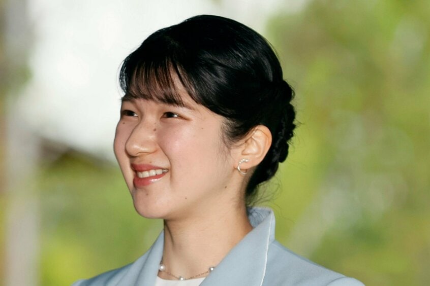 大阪・関西万博会場の「EARTH MART」に到着した愛子さま。赤のリップが美しく映える。後ろの襟を立ち上げてボリュームを出したデザインは、母の雅子さまもお好みだった=2025年5月9日午後3時28分、大阪市此花区