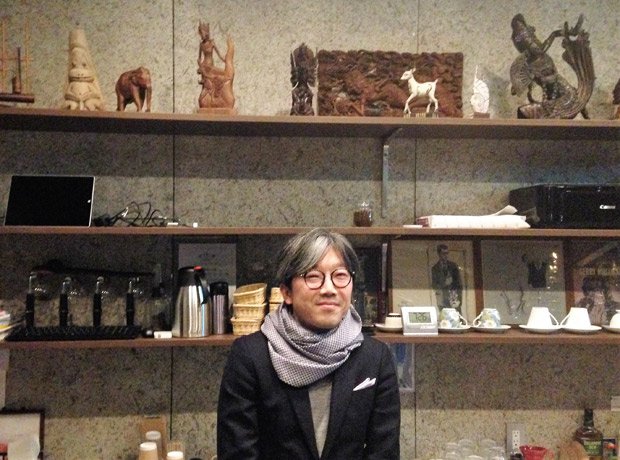 純喫茶「ツタヤ」の4 代目店主・宇瀬崇さん。カウンターには東南アジアの木工品が並ぶ