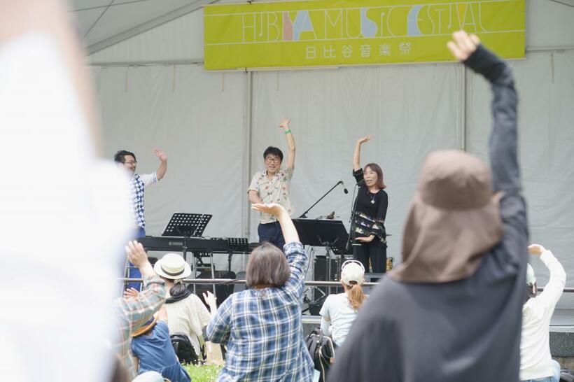 日比谷音楽祭の会場ではラジオの公開放送も行われた。ハウスバンド「The　Music　Park　Orchestra」を率いてステージに立ち、ベースを弾き熱くなった手を楽屋裏で人知れず冷やす（撮影／門間新弥）