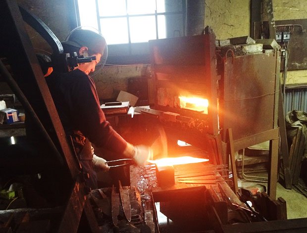 鍛冶職人の田中さんが、真っ赤になった鉄を打ち付け、刃の部分を作る（匠工芸提供）