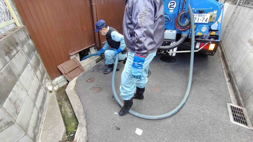 ホースを固定しながら吸引していく(写真:筆者撮影)