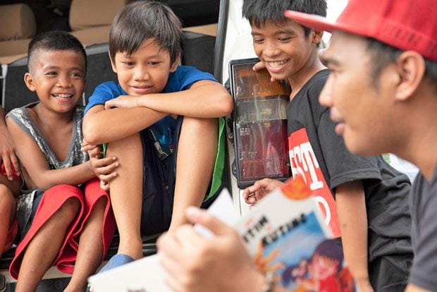 「国境なき子どもたち」は毎週、ストリートチルドレンに絵本を読み聞かせる活動をしている。ストーリーに引き込まれるヨハン君（左から２人目）（撮影／清水匡）