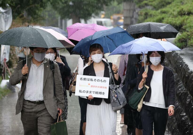 最高裁（左）大法廷は家事審判の決定で、夫婦同姓を定めた民法などの規定は憲法24条の「婚姻の自由」に違反しないと判断した。決定を前に、最高裁に入る申立人と弁護団（上）／2021年６月23日