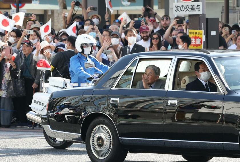 沿道で出迎える人たちに車内から手を振る上皇さま＝５月１６日、奈良市