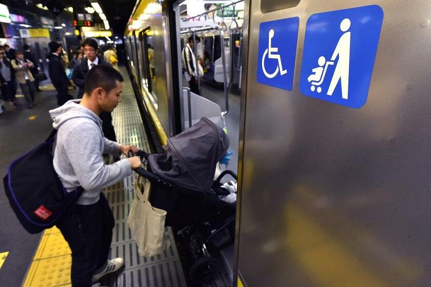 ベビーカーマークがついた車両に乗り込む乗客。２０１５年ＪＲ新宿駅で