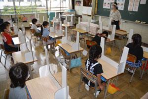 学校再開にあたり、教育現場は感染予防に細心の注意を払っている。6月1日、埼玉県の小学校の教室では机に飛沫拡散防止スクリーンが置かれ、先生はフェースシールドを着用した　（ｃ）朝日新聞社