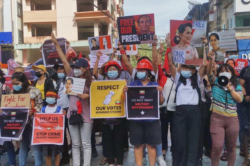 ヤンゴンでアウンサンスーチー氏の写真を掲げてデモをする人々　(Ｃ)朝日新聞社