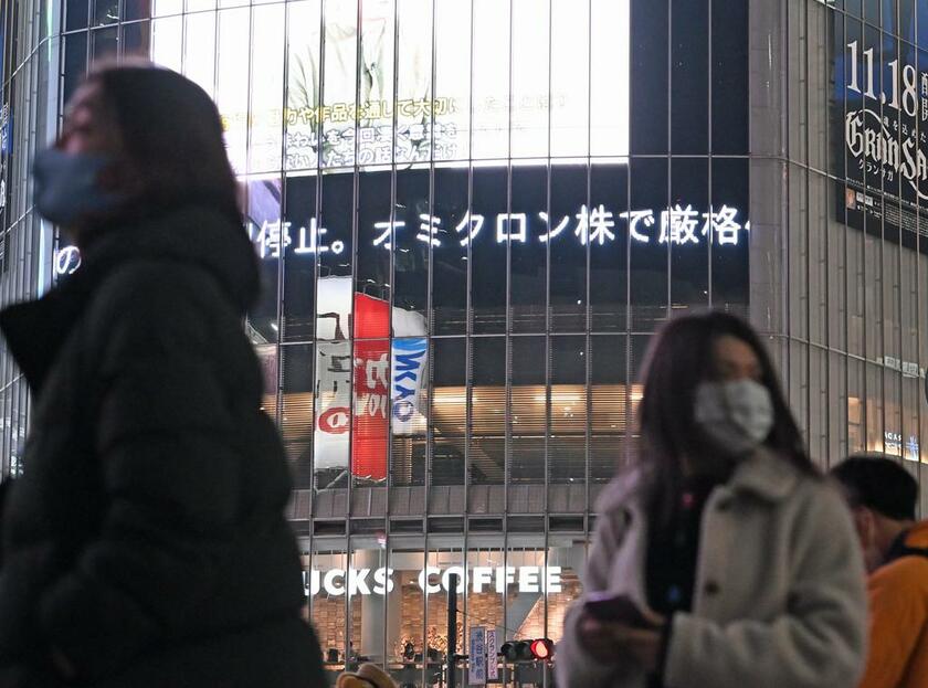 東京・渋谷の大型ビジョンを流れる、新型コロナウイルスの変異株「オミクロン株」の文字。世界各国が対策を講じている