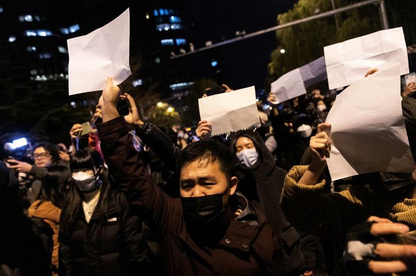 北京で新型コロナウイルス対策の規制に抗議して白い紙を掲げる人たち＝2022年11月27日（photo　アフロ）