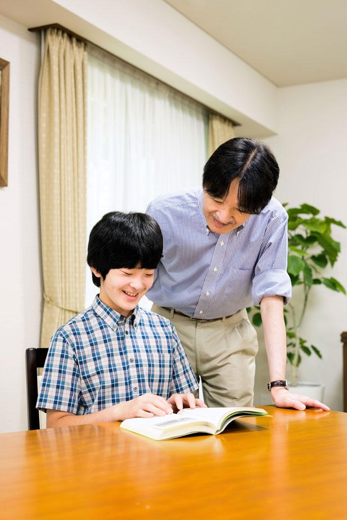 本を一緒に眺める秋篠宮さまと悠仁さま（宮内庁提供）