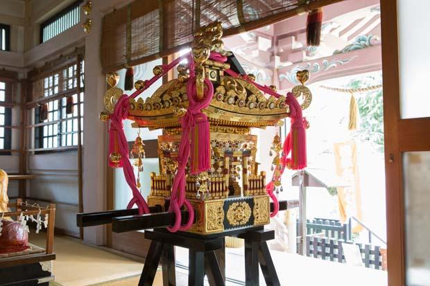 猫の姿が彫られているお神輿。神社によると金色は、「縁起の良い色。特に金運に良く、飾り紐のピンクは恋愛運を上げる」とか。女性の参拝者が多いのも納得（撮影／写真部・片山菜緒子）