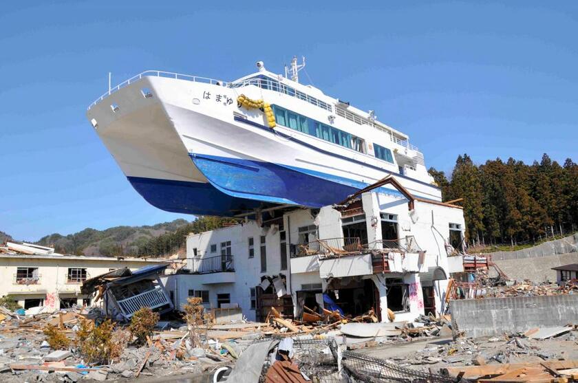 2011年3月の東日本大震災による津波で、民宿の上に乗り上げた観光船＝岩手・大槌町（c）朝日新聞社