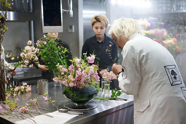 スタッフが取り囲む作業台で黙々と花を挿す（撮影／写真部・大野洋介）