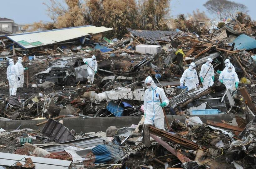 ２０１１年の東日本大震災による津波で壊滅的な被害を受けた福島県浪江町。防護服を着た警察官らによる捜索が続いていた＝同年４月２５日