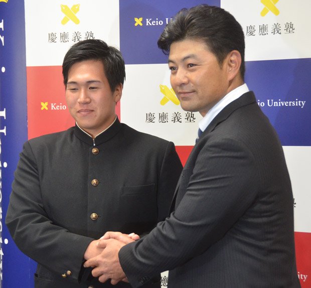 広島・緒方監督（右）と握手する、広島ドラフト1位指名を受けた慶大の加藤（c）朝日新聞社